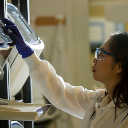 researcher smiling as she looks at laptop