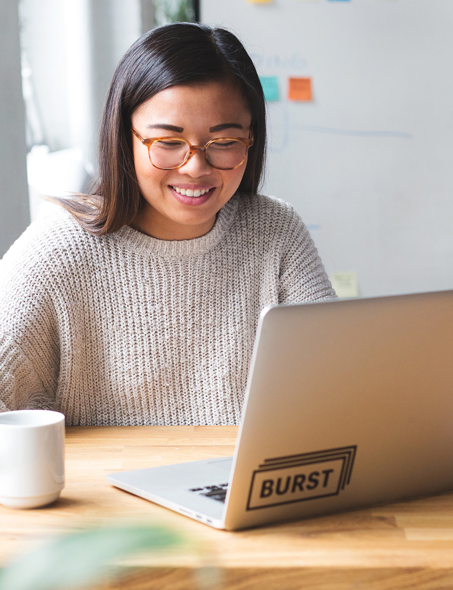 researcher smiling as she looks at laptop